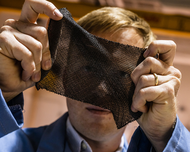 DexMat CTO Dmitri holds a piece of Galvorn fabric stretched between his hands