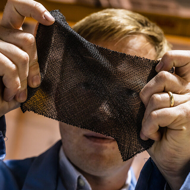 DexMat CTO Dmitri holds a piece of Galvorn fabric stretched between his hands