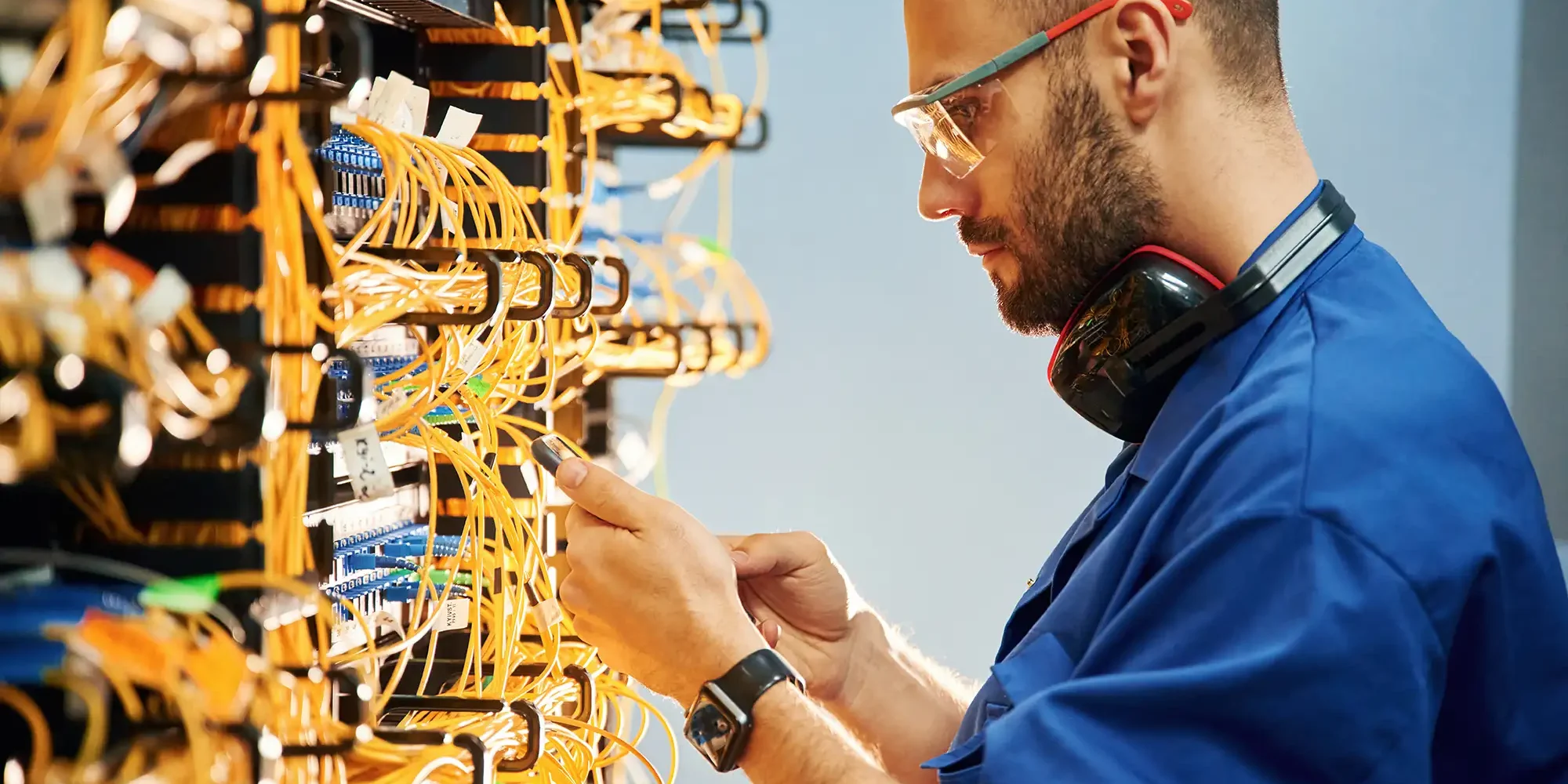 data-center-cables Young man is working with internet equipment and wires in server room